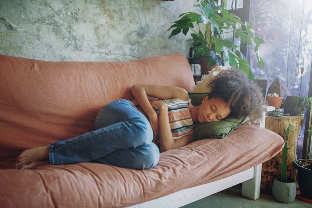 Femme allongée sur un canapé à cause de douleurs d'endométriose