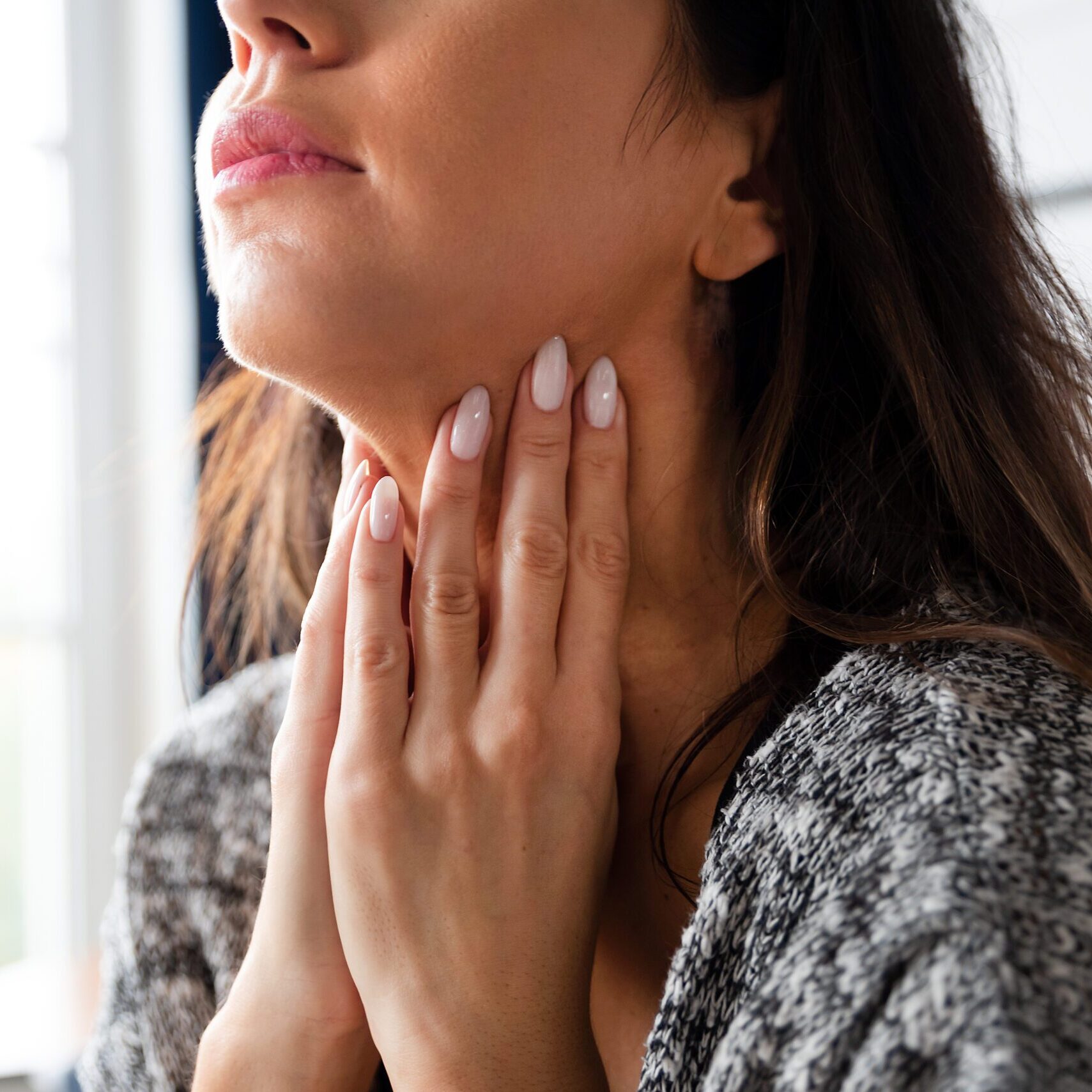 Female checking thyroid gland by herself. Women thyroid gland control